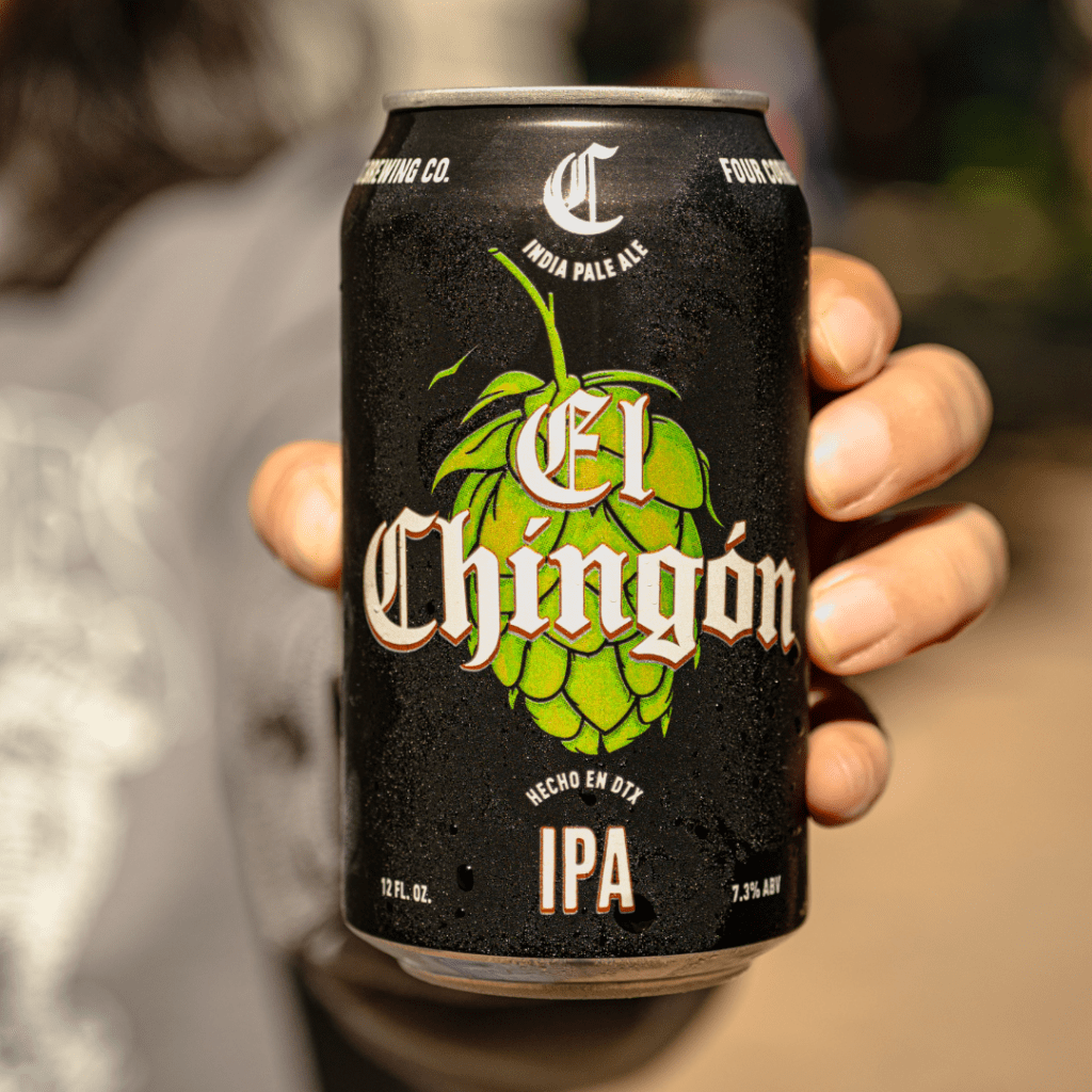 Hand holding a Four Corners El Chingón IPA can showing hop illustration, Hecho en DTX, and 7.3% ABV label details